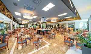 Suuri ravintola-alue, jossa on paljon pöytiä ja tuoleja. (Tekoälyn luoma teksti)