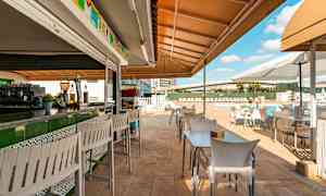 Ulkoterassi, jossa pöytiä ja tuoleja uima-altaan lähellä. (Tekoälyn luoma teksti)