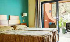 Hotellihuone, jossa kaksi erillistä vuodetta ja parveke näkymällä. (Tekoälyn luoma teksti)