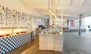 Kuva buffetravintolasta, jossa on meriteemainen sisustus ja katetut pöydät. (Tekoälyn luoma teksti)