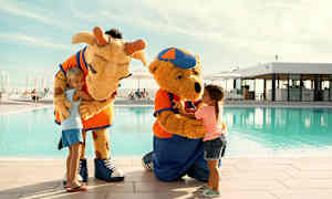 Kaksi eläinpukuista hahmoa uima-altaan äärellä vuorovaikuttaen lasten kanssa. (Tekoälyn luoma teksti)