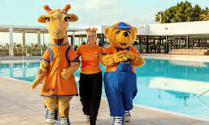 Kaksi maskottia, kirahvi ja nalle, uima-altaan äärellä lomakeskuksessa. (Tekoälyn luoma teksti)