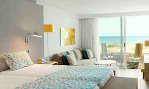 Hotellihuone, josta näkyy hiekkaranta ja meri. (Tekoälyn luoma teksti)