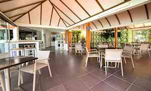 Ravintola, jossa istuinryhmiä ja kattopalkkeja. (Tekoälyn luoma teksti)