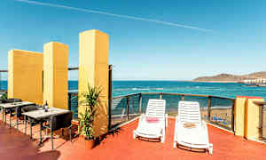 Terassi merinäköalalla, varustettuna aurinkotuoleilla, pöydillä ja tuoleilla. (Tekoälyn luoma teksti)