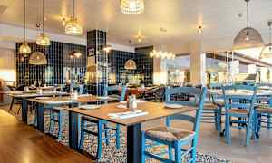 Ravintola, jossa pöydät ja siniset tuolit. (Tekoälyn luoma teksti)