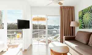 Valoisan hotellihuoneen sisätila, parveke ja näkymä laaksoon. (Tekoälyn luoma teksti)