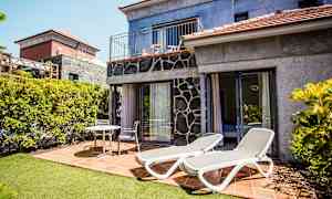 Kuva terassista, jossa on aurinkotuoleja ja istuimia talon vieressä. (Tekoälyn luoma teksti)