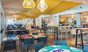 Ravintolan sisustus, jossa on katettu pöytiä ja tuoleja. (Tekoälyn luoma teksti)