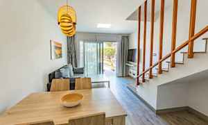 Olohuone, jossa pöytä, tuolit, sohva ja portaikko. (Tekoälyn luoma teksti)