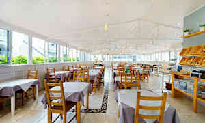 Tilava ravintola, jossa pöydät ovat violetilla ja valkoisilla liinoilla. (Tekoälyn luoma teksti)