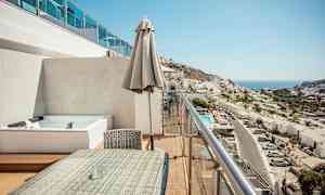 Parveke, jossa istuinryhmä ja näkymä kaupunkiin ja merelle. (Tekoälyn luoma teksti)