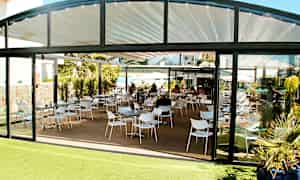 Kuva ravintolasta, jossa ulkona istuma-alue ja lasiseinät. (Tekoälyn luoma teksti)