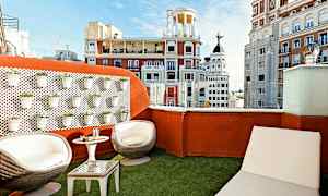 Kattoterassi, jossa istuimia ja näkymä kaupungin arkkitehtuuriin. (Tekoälyn luoma teksti)