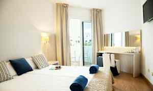 Hotellihuone kahdella yhden hengen vuoteella, parvekkeella ja työpöydällä. (Tekoälyn luoma teksti)