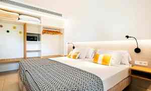 Hotellihuone, jossa on parivuode, lukulamput ja vaatekaappi. (Tekoälyn luoma teksti)