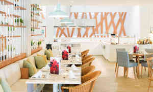 Avoin ravintolatila, jossa pöytiä, tuoleja ja koristeellisia puupaneeleja. (Tekoälyn luoma teksti)