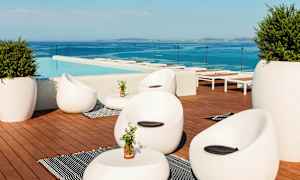 Loungealue uima-altaan äärellä, jossa on nykyaikaisia huonekaluja ja näkymä merelle. (Tekoälyn luoma teksti)