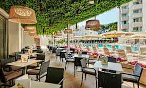 Ulkoilmaravintola pöytien ja tuolien kanssa, uima-altaan ja aurinkotuolien vieressä aurinkovarjojen alla. (Tekoälyn luoma teksti)