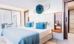 Makuuhuone, jossa on parisänky ja vaalea, moderni sisustus. (Tekoälyn luoma teksti)