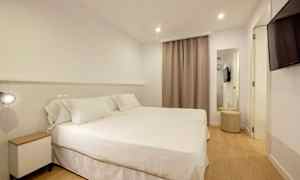 Hotellihuone, jossa on kaksi sänkyä valkoisilla vuodevaatteilla. (Tekoälyn luoma teksti)