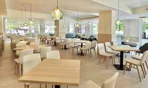 Moderni ja valoisa sisäravintola, jossa on puiset kalusteet ja koristeelliset valaisimet. (Tekoälyn luoma teksti)