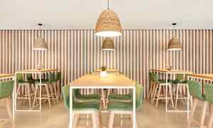 Kuva modernista ravintolasisustuksesta, jossa on puupöytiä ja -tuoleja sekä vihreitä yksityiskohtia, ja riippuvalaisimia. (Tekoälyn luoma teksti)