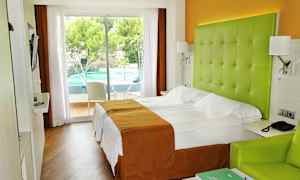 Hotellihuone, jossa parivuode, vihreä pääty ja näkymä ulkouima-altaalle. (Tekoälyn luoma teksti)