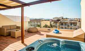 Terassi porealtaalla, sohvalla ja ympäröiviin rakennuksiin avautuvalla näkymällä. (Tekoälyn luoma teksti)