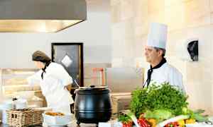 Kaksi kokkia tarjoilupisteellä vihanneksilla ja ruoalla. (Tekoälyn luoma teksti)