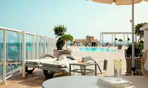 Näköala uima-altaalle, jossa on aurinkotuoleja ja varjoja. (Tekoälyn luoma teksti)