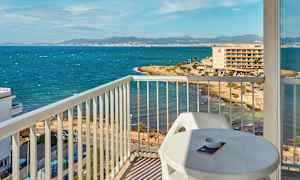 Näkymä parvekkeelta rannikolle, jossa meri ja rakennuksia taustalla. (Tekoälyn luoma teksti)