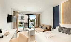 Hotellihuone, jossa parivuode, sohva ja parveke, joka avautuu uima-altaalle. (Tekoälyn luoma teksti)