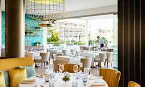 Ravintola, jossa on katettuja pöytiä ja tyylikäs sisustus. (Tekoälyn luoma teksti)