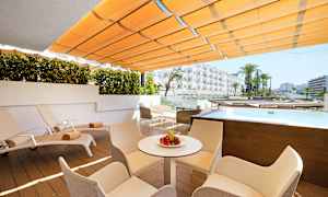 Ulkoterassi, jossa aurinkotuoleja, pöytä ja tuoleja. Pieni uima-allas, näkymä hotellirakennuksiin. (Tekoälyn luoma teksti)