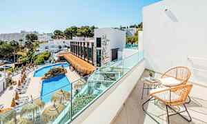 Näkymä parvekkeelta, jossa on kaksi tuolia ja pöytä, uima-altaalle ja rakennuksiin, joita ympäröi vehreys. (Tekoälyn luoma teksti)