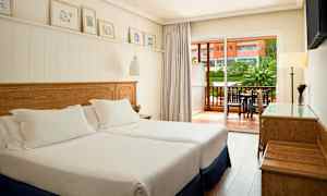 Hotellihuone, jossa kaksi erillistä vuodetta ja parveke ulkopuolella. (Tekoälyn luoma teksti)