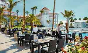 Ravintola-alue ulkopaikoilla, palmut ja uima-altaat ympärillä. (Tekoälyn luoma teksti)