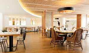 Moderni ravintola, jossa on tyylikkäitä kalusteita ja katettuja pöytiä. (Tekoälyn luoma teksti)