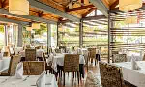 Ravintola, jossa on katettuja pöytiä ja suuret ikkunat. (Tekoälyn luoma teksti)