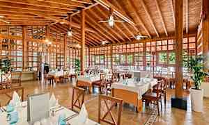 Ravintola, jossa puiset sisätilat, katetut pöydät ja tuolit. (Tekoälyn luoma teksti)