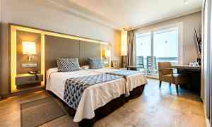 Hotellihuone, jossa on kaksi yhden hengen vuodetta, nykyaikaiset huonekalut ja parveke näköalalla. (Tekoälyn luoma teksti)