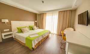 Hotellihuone, jossa on parivuode, vihreät yksityiskohdat ja nykyaikainen sisustus. (Tekoälyn luoma teksti)