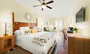 Valoisa hotellihuone, jossa on parivuode, puiset yksityiskohdat ja moderni sisustus. (Tekoälyn luoma teksti)