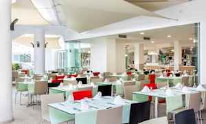 Ravintola, jossa katettuja pöytiä ja värikkäitä tuoleja. (Tekoälyn luoma teksti)