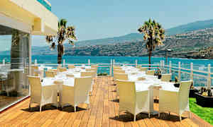 Ulkoterassi ruokapöytineen ja tuoleineen, näkymä merelle ja ympäröivään maisemaan. (Tekoälyn luoma teksti)