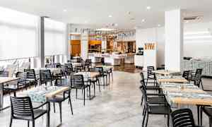 Ruokasali, jossa on pöytiä ja tuoleja sekä koristeita katossa. (Tekoälyn luoma teksti)