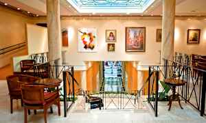 Tyylikkään rakennuksen sisätila seinillä olevien taideteosten ja ympärillään olevien istumapaikkojen kanssa. (Tekoälyn luoma teksti)