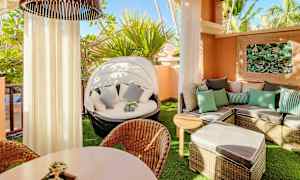 Kalustettu parveke, jossa on aurinkotuoleja, pöytä ja kasvikoristeita. (Tekoälyn luoma teksti)