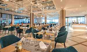 Ravintola, jossa on katettuja pöytiä ja tuoleja. (Tekoälyn luoma teksti)